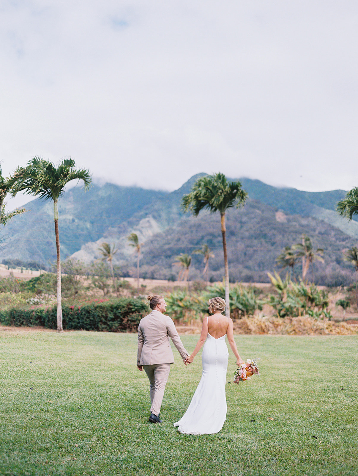 A bride and groom walking in Cafe Olei on Maui