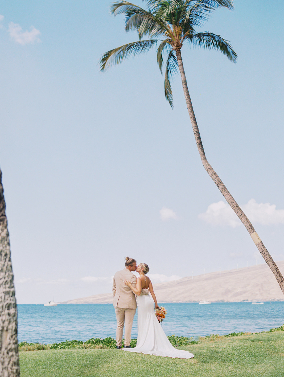 bride and groom kissing on sugar beach in kihei